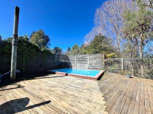 a swimming pool on a wooden deck with a fence at All decked out in Rotorua
