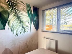 a bedroom with a mural of a plant on the wall at Ermrest Cottage in Erm