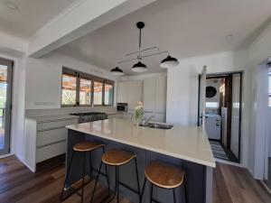 a kitchen with a large island with two bar stools at All decked out in Rotorua