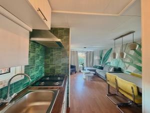 a kitchen with a sink and a living room at Ermrest Cottage in Erm