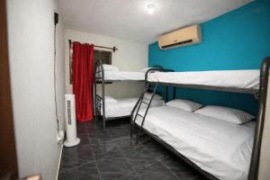a room with three bunk beds and a blue wall at Villa azul círculo auto in Jarabacoa +18 photos