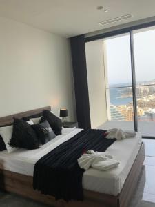 a bedroom with a large bed with a large window at Whispering Waves at Mercury Tower with panoramic view , 2X pools and Gym in Paceville +59 photos
