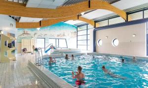 a group of people swimming in a swimming pool at Het mooiste plekje van het park in Kropswolde