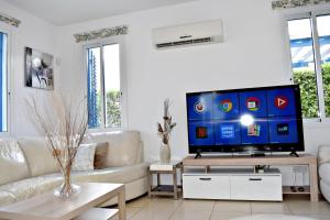 a living room with a large flat screen tv at Latchi Beach Front Villa - Private Heated Pool - Amazing Uninterrupted Sea Views in Polis Chrysochous
