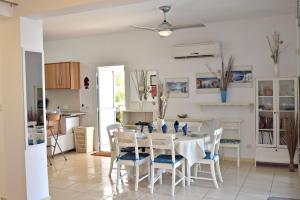a kitchen and dining room with a table and chairs at Latchi Beach Front Villa - Private Heated Pool - Amazing Uninterrupted Sea Views in Polis Chrysochous +42 photos