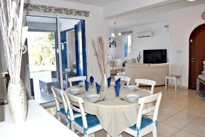a dining table and chairs in a living room at Latchi Beach Front Villa - Private Heated Pool - Amazing Uninterrupted Sea Views in Polis Chrysochous