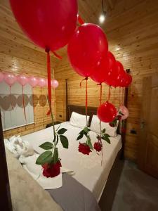 ein Bett mit daran befestigten roten Luftballons in der Unterkunft Cherry farm in Adschlun
