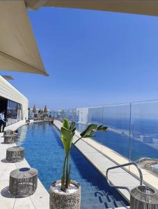 a swimming pool with a potted plant on top of a building at Whispering Waves at Mercury Tower with panoramic view , 2X pools and Gym in Paceville