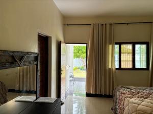 a bedroom with a bed and a desk with a laptop at Bella House in Inhambane