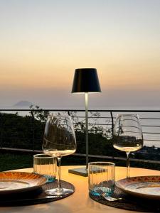 a table with wine glasses and a lamp on it at BLUE APARTMENT in VILLA ANGISI in Drapia