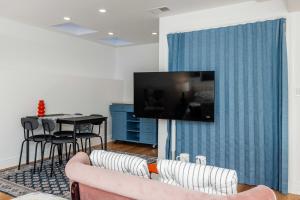 a living room with a couch and a tv on a wall at Huh's Lodge in San Francisco