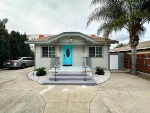 a house with a blue door and a driveway at Coastal Calm Casita in Long Beach