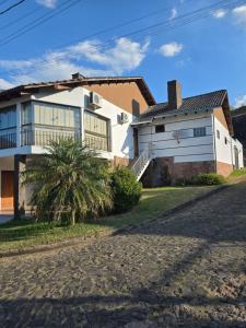 a house with a palm tree in front of it at Premium house with pool in Santana do Livramento