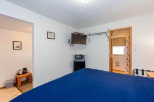 a bedroom with a blue bed in a room at Cascade Motel in Oakridge
