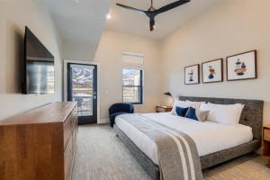 a bedroom with a bed and a tv and windows at Helling Circle Hideaway 303 in Heber City