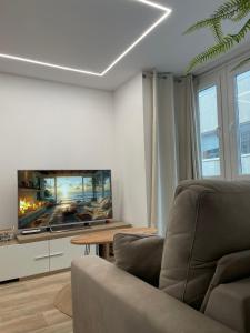 a living room with a couch and a flat screen tv at Pontevedra Apartments -New Loft Centro Pontevedra in Pontevedra