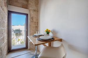 a table and a chair in a room with a window at Old tuff apartments in Polignano a Mare