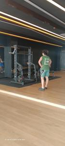 a man standing in a gym with his arms crossed at Mesahill Home Stay Nilai in Nilai