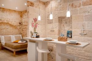 a bathroom with a counter in a room with stone walls at Old tuff apartments in Polignano a Mare