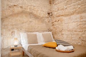a bedroom with a bed in a stone wall at Old tuff apartments in Polignano a Mare
