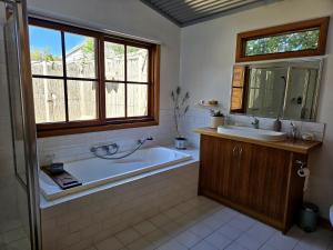 a bathroom with a tub and a sink and a mirror at Cedar Hill Retreat in Venus Bay +23 photos