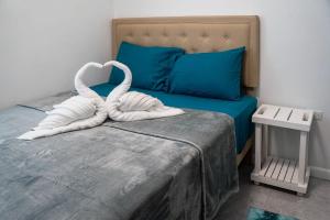 a bed with two white swans towels on it at East Lake Oasis in Arima