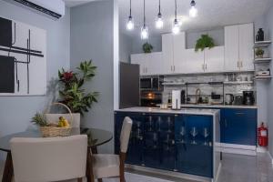 a kitchen with a blue island with a table and chairs at East Lake Oasis in Arima