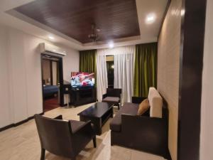 a living room with a couch and chairs and a television at O-lumis Nexus Apartment in Tuaran