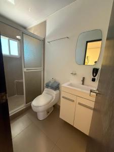 a bathroom with a toilet and a sink and a mirror at Marvella Club in Nueva Gorgona