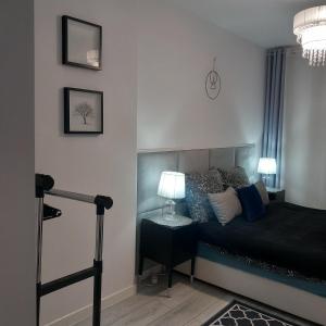 a bedroom with a bed and a table with a lamp at Apartament z kominkiem RetroGlam in Mieroszów