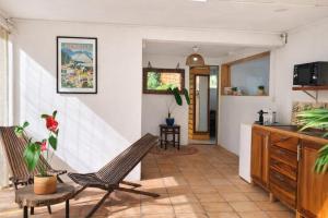 a living room with a chair and a kitchen at Studio Anthurium in Gros-Morne