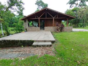 a small building with a porch in a field at Casa Recanto do Sossego in Antonina