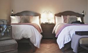 a bedroom with two beds and a chair at Hollywood Hotel in Los Angeles