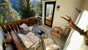 a porch with a couch and chairs on a balcony at Chalet DolceVista con SPA, vicino a Cortina d'Ampezzo in Borca di Cadore