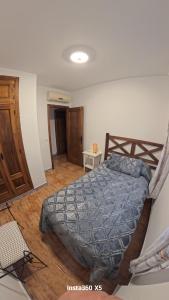 a bedroom with a bed with a blue comforter at El Bosque Nomada 4 in El Bosque