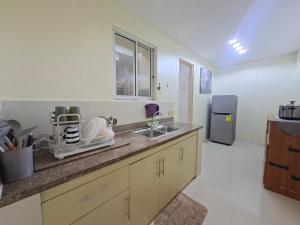a kitchen with a counter and a sink and a refrigerator at Abode86-PGT Townhouse2 in Lapu Lapu City +2 photos