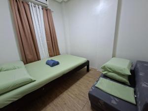 a small room with two beds and a window at Abode86-PGT Townhouse2 in Lapu Lapu City