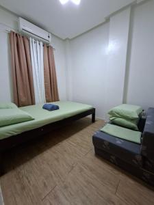 a room with two beds and a window at Abode86-PGT Townhouse2 in Lapu Lapu City