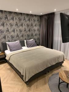 a bedroom with a large bed and a flat screen tv at Bella Vita Hotel Restaurant in The Hague