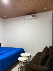 a room with a bed and a couch and two tables at Raya Homestay in Kuta Lombok