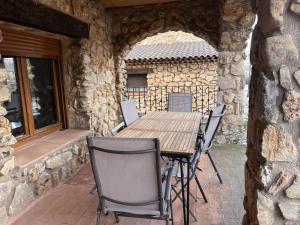 a wooden table and chairs on a patio at Refugio del Mundo in Riópar