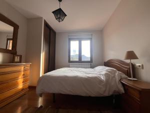 a bedroom with a bed and a dresser and a window at Refugio del Mundo in Riópar