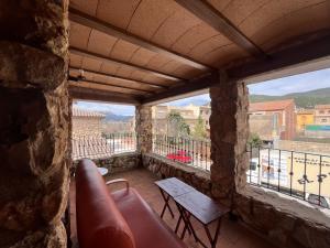 a balcony with a couch and a table and windows at Refugio del Mundo in Riópar