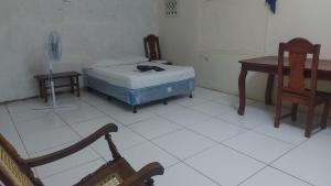 a room with a bed and a desk and a chair at Hostal Brisas del Ometepe in Rivas