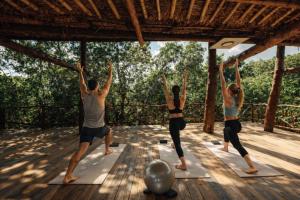 a group of people doing yoga on a deck at ARKA Tulum in Tulum