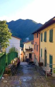an alley with buildings and a mountain in the background at L'Antica Locanda da Gigino in Corniolo