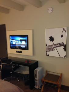 a bedroom with a television and a desk with a chair at Hollywood Hotel in Los Angeles