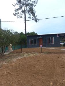 a house with a red door in a yard at Grazie Carpe in Jaureguiberry