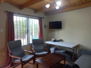 a living room with two chairs and a table and a window at Grazie Carpe in Jaureguiberry