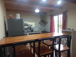 a kitchen with a wooden table and a refrigerator at Grazie Carpe in Jaureguiberry